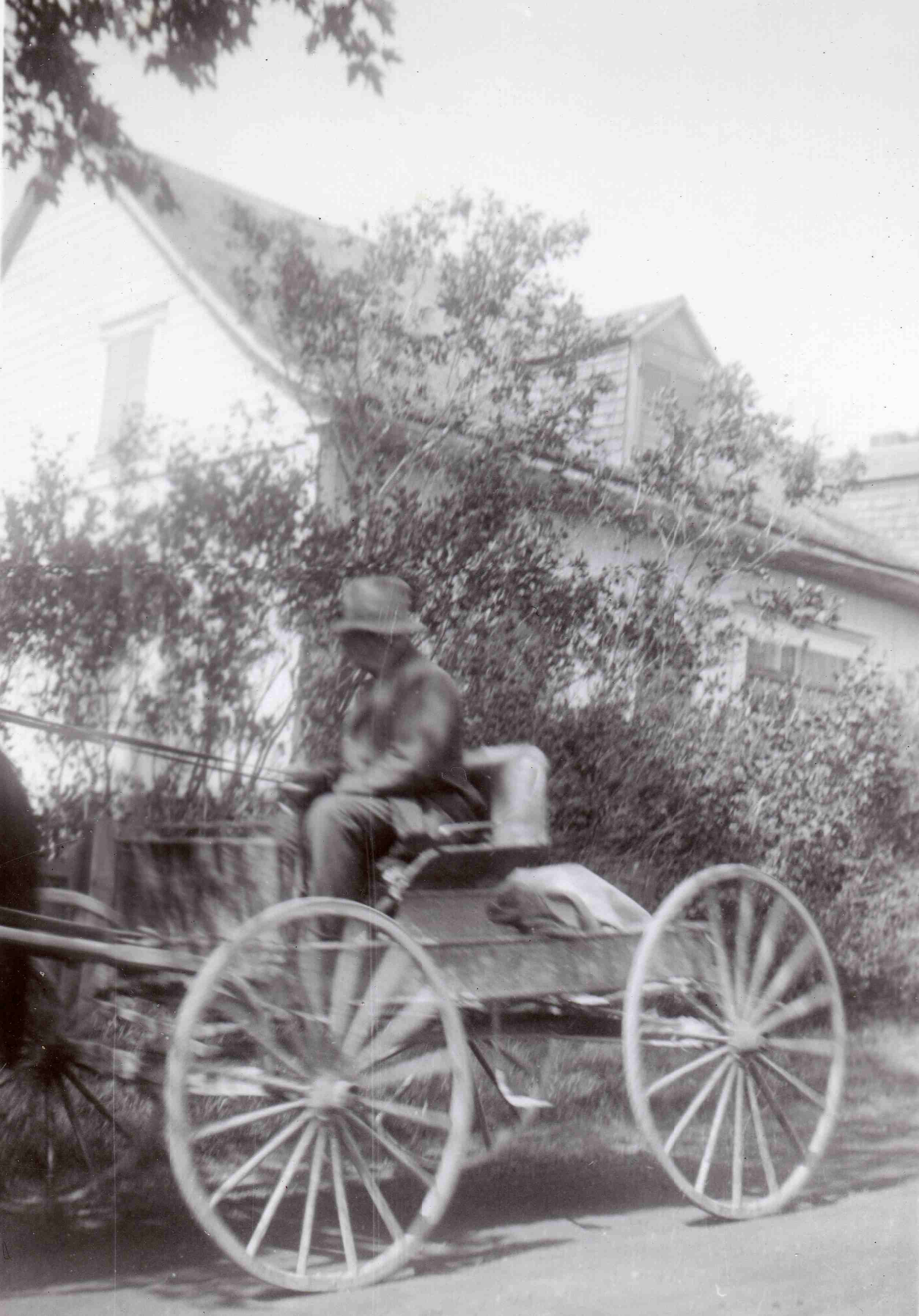 man drives a rustic four-wheeled horse-drawn carriage.