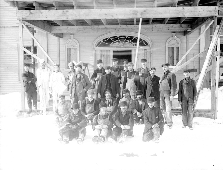 Des ouvriers posent devant une maison en construction.