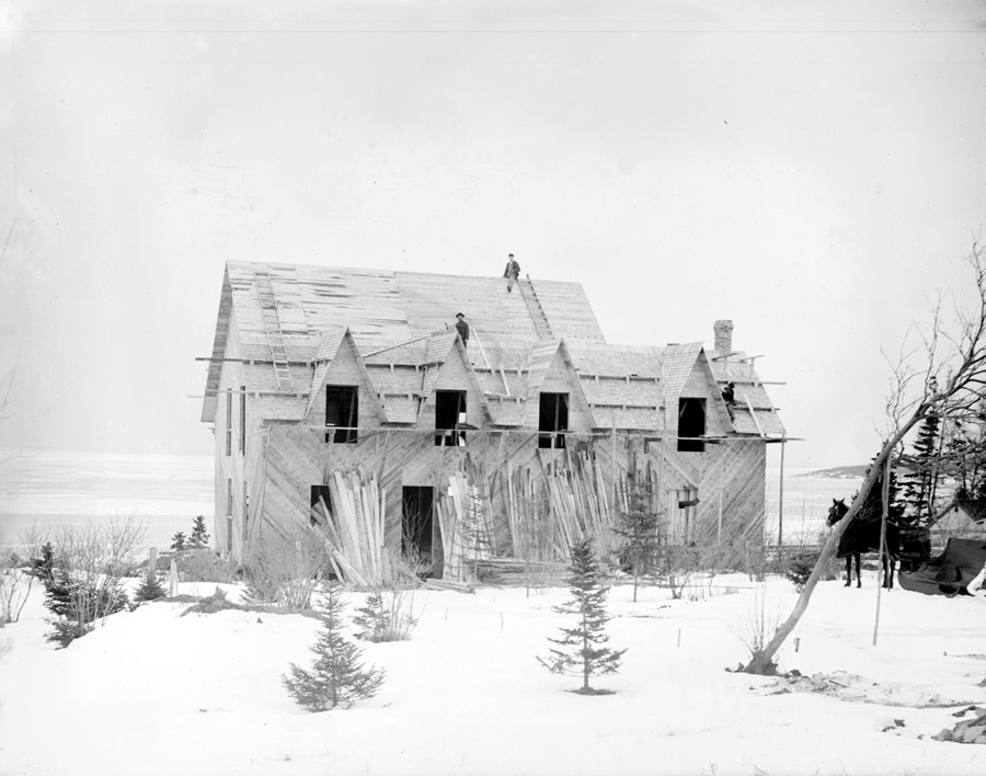 Workers on the roof of a house being built in winter.