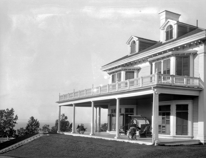 A villa surrounded by a huge porch overlooking the river.