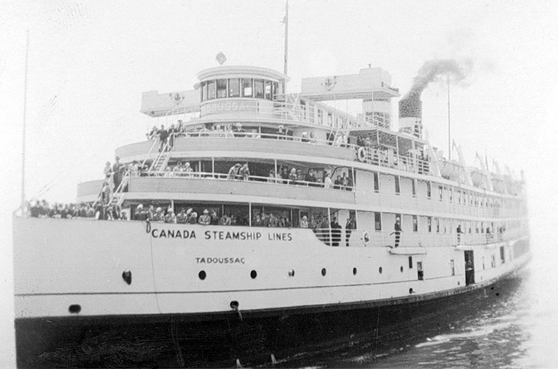 A cruise steamer with passengers on deck.