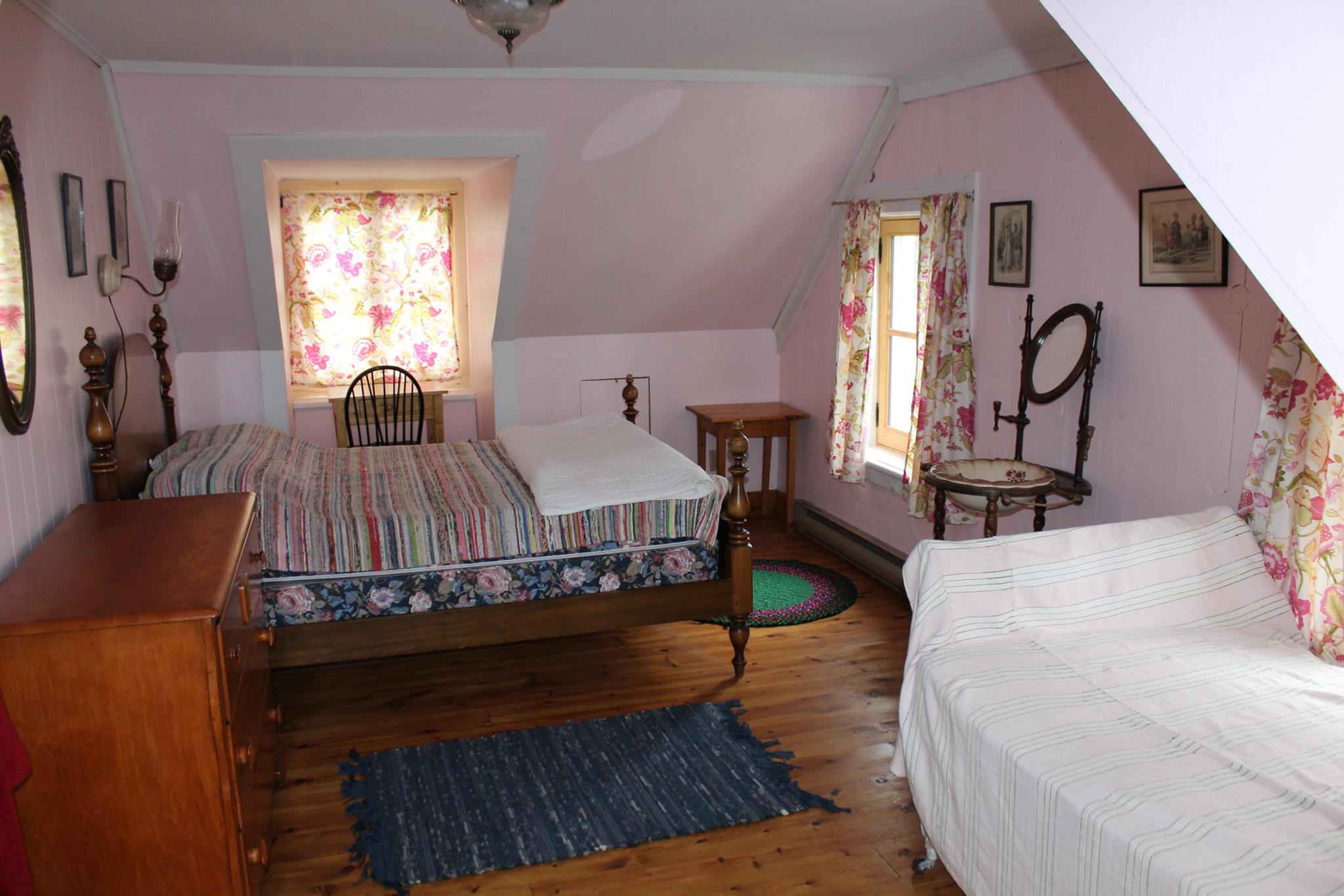 A colour photograph of a small bedroom with old-fashioned furnishings