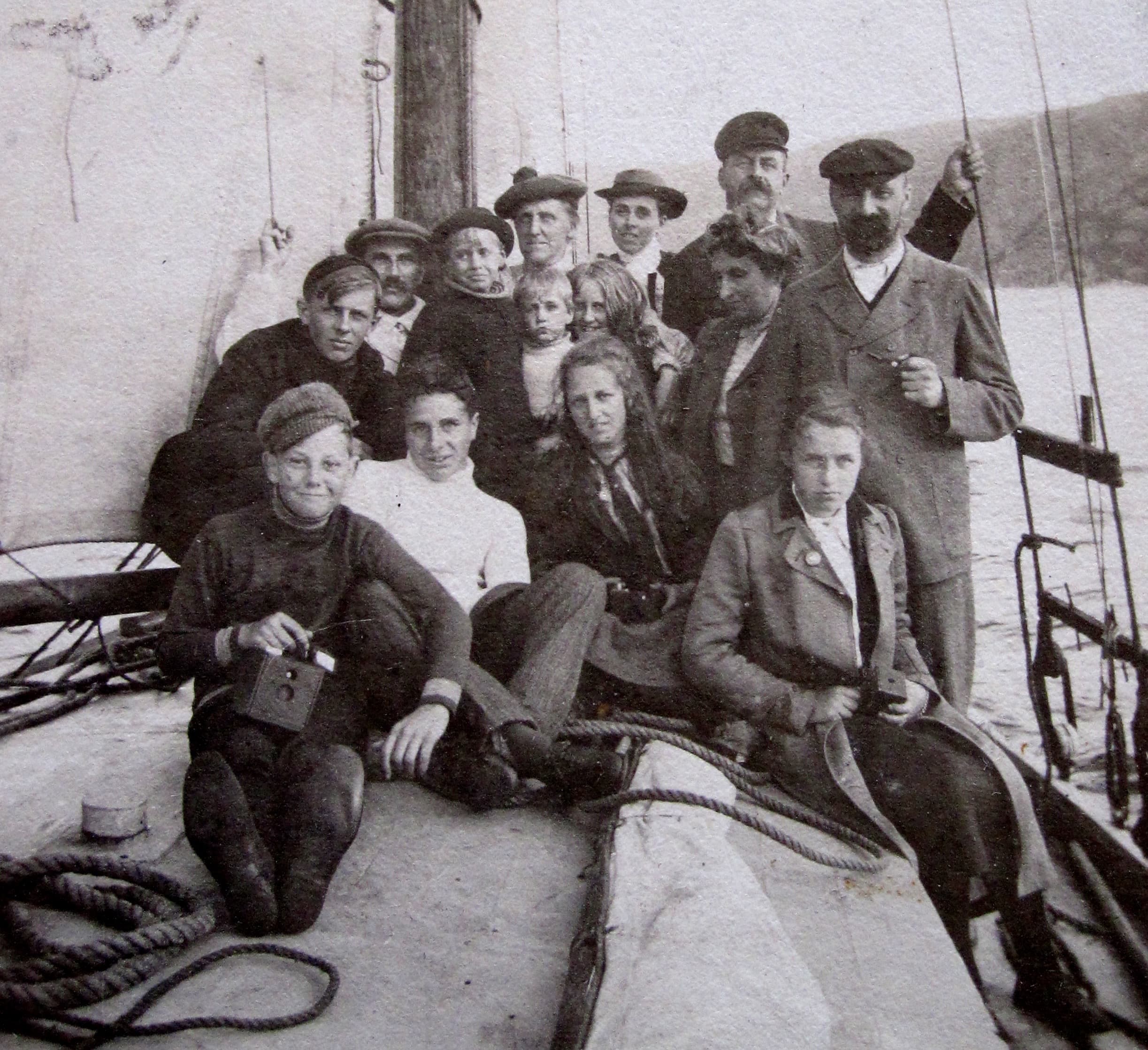 A group of vacationers pose on the deck of a sailboat.