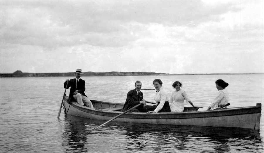 A small group in a rowboat, on the water.