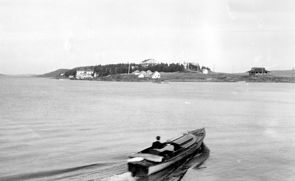 A man in a small boat heading towards the Point.