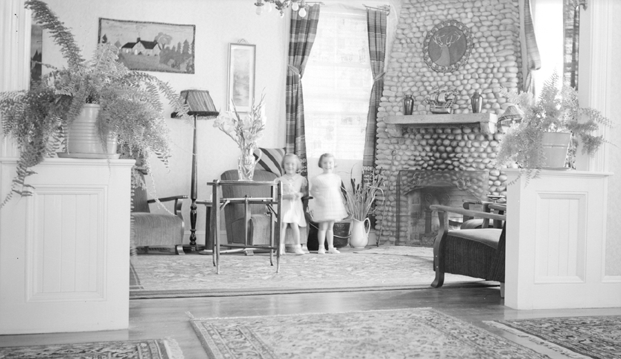 Deux petites filles en robe blanche posent dans le salon d’un hôtel.