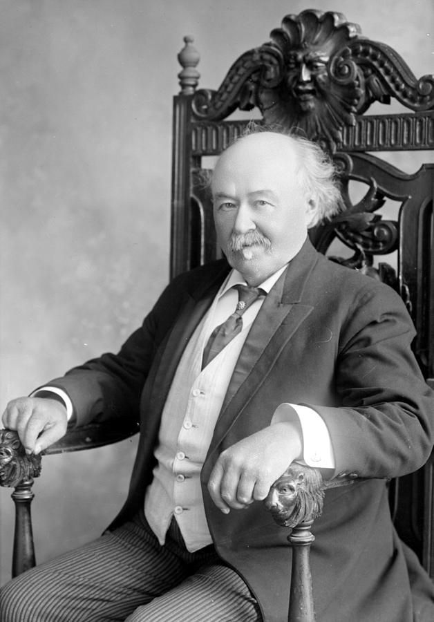 Portrait of a man sitting in a chair with lion-head armrests.