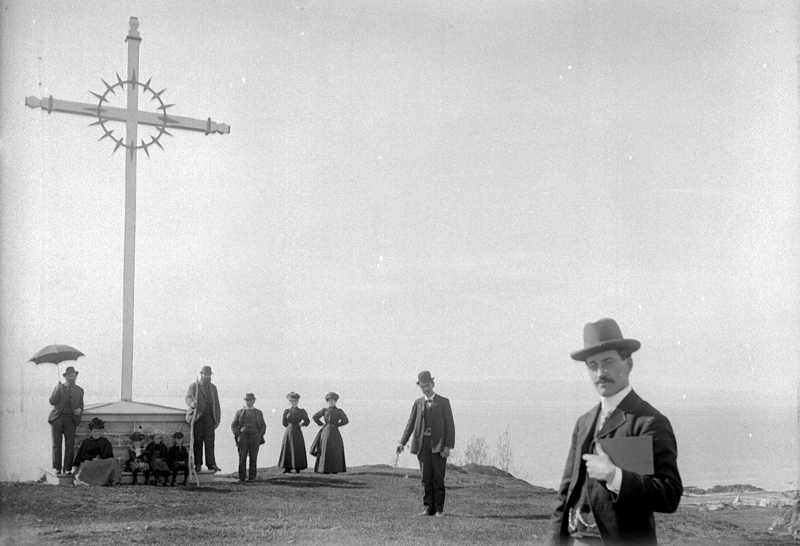A group gathered at the foot of a wayside cross in Saint-Denis-De La Bouteillerie.