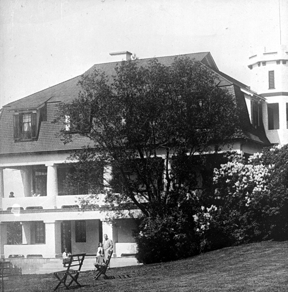 A large house with broad porches on two floors all around and a turret.