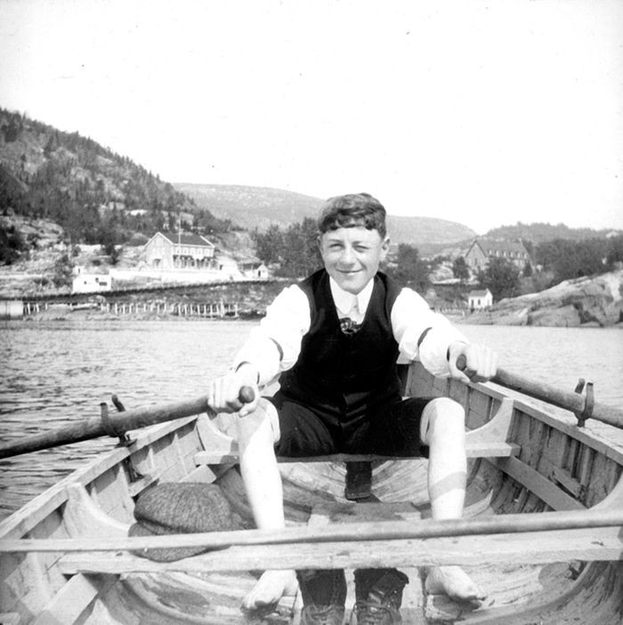 A young man sitting in a rowboat.