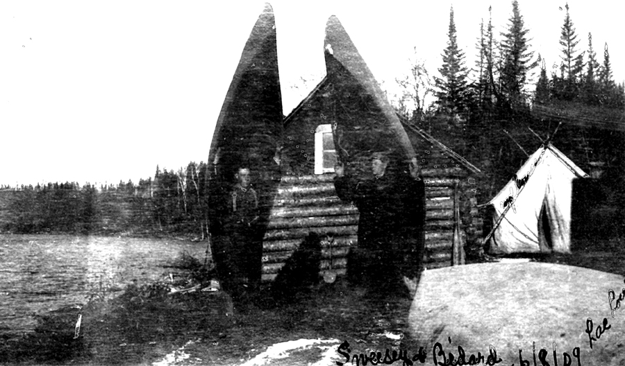 Two men carrying their canoes on their shoulders.