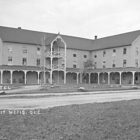 Photograph of a large hotel bordered by a well maintained lawn.