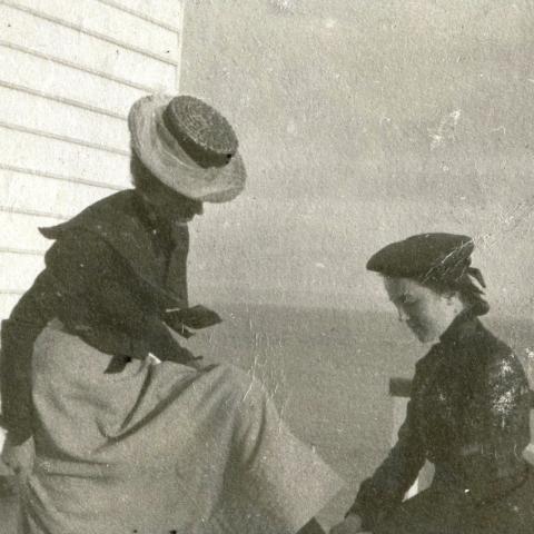 Une jeune femme lasse les chaussures d'une dame assise.