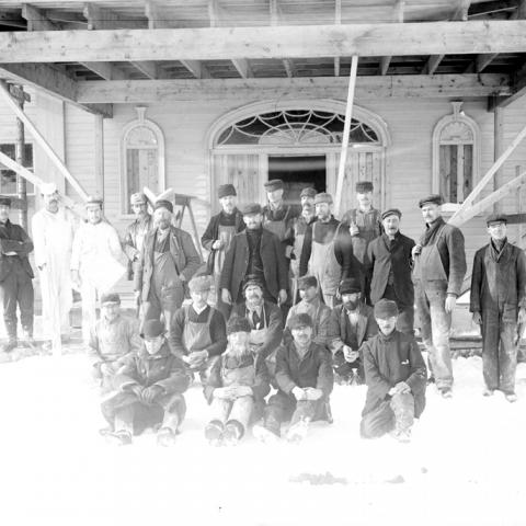 Workers posing in front of a house under construction.