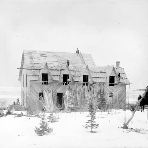 Workers on the roof of a house being built in winter.