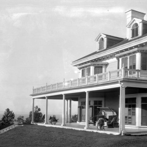 A villa surrounded by a huge porch overlooking the river.