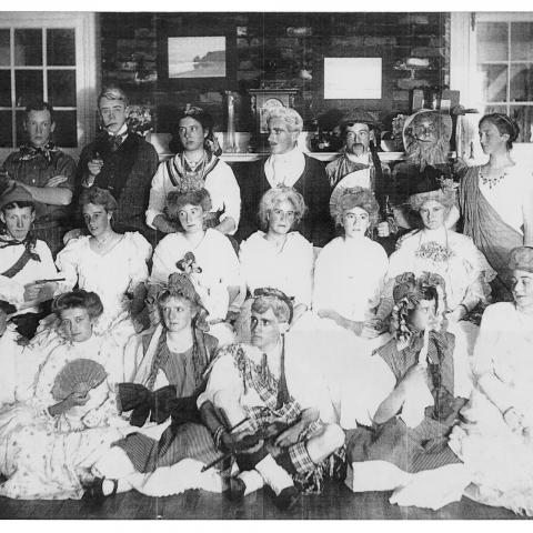 Two dozen adolescents in party costumes strike a pose inside a villa.