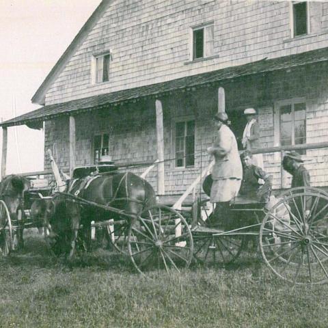 Photograph of a large family on steps leading to a veranda.