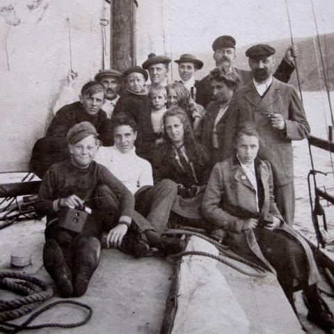 Un groupe de vacanciers pose sur le pont d'un petit bateau.