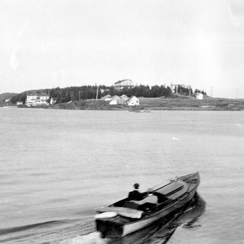 A man in a small boat heading towards the Point.