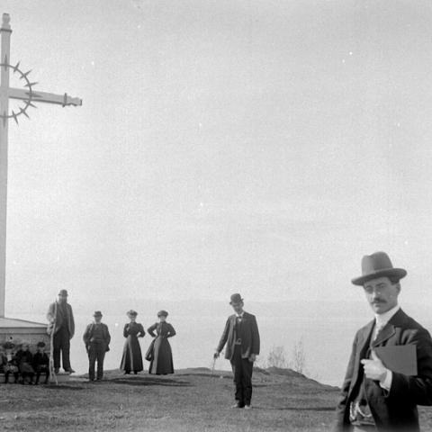 A group gathered at the foot of a wayside cross in Saint-Denis-De La Bouteillerie.