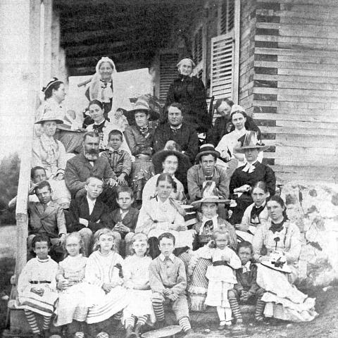 Photographie d'une grande famille dans les marches d'une galerie.